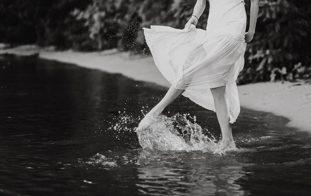 girl on the beach in the sea splashing water with her feet - Φωτογραφία, εικόνα