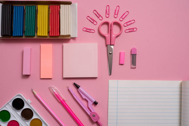 Stationary concept, Flat Lay top view Photo of Scissorsschool supplies, notepad and pens, color pencils, on a pink background. pink background with copy space. - Foto, Bild