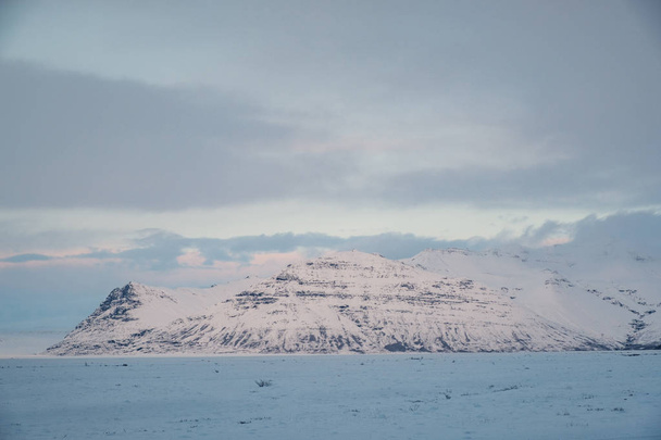 Dramatic icelandic landscape with snow covered mountains. Cold winter day in Iceland. - Valokuva, kuva