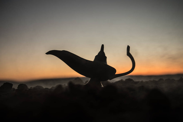 Антикварная ремесленная арабская ночь Аладдина в стиле джинна масляная лампа с мягким белым дымом. Фон солнца. Лампа желаний. Селективный фокус
 - Фото, изображение