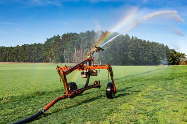 Innaffiare un campo con un sistema di irrigazione
 - Foto, immagini