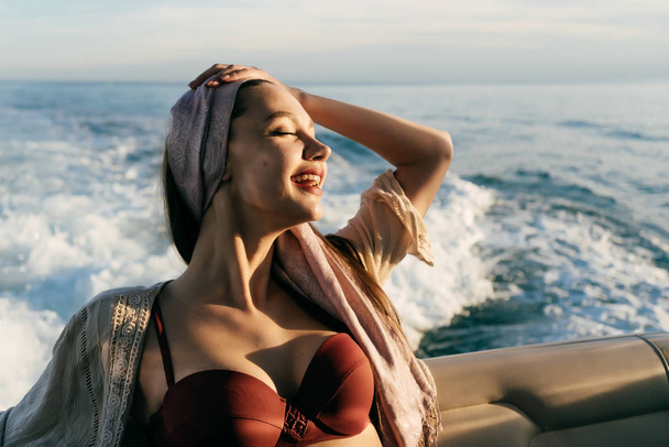 luxurious happy young girl resting on her yacht in the sun, long-awaited vacation - Фото, изображение