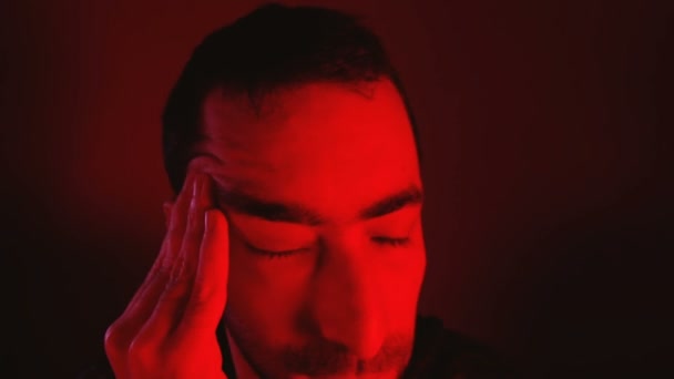 Man with closed eyes rubs his head and suffering from pain - Footage, Video