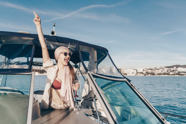 boldog nevető fiatal nő napszemüveg úszik a vele fehér jacht a Karib-tenger, felemelte a kezét, és vidáman időt tölt - Fotó, kép