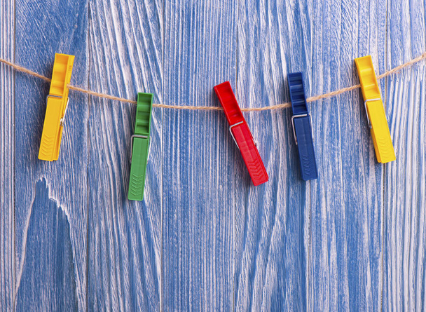 Pinzas de plástico de colores sobre fondo de madera azul
 - Foto, Imagen