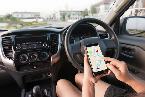 Hand of woman using smartphone with gps navigator map application in SUV car - 写真・画像