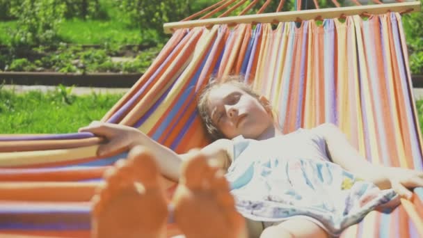Meisje slaapt in hangmat op zonnige dag. - Video