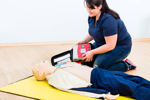 Eerste aider stagiair leren revival met defibrillator - Foto, afbeelding