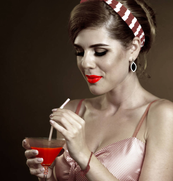 Дівчина п'є кривавий коктейль Мері. Штифт-ап ретро жіночий стиль
. - Фото, зображення