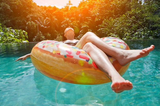 дівчина в басейні на надувному кільці
 - Фото, зображення