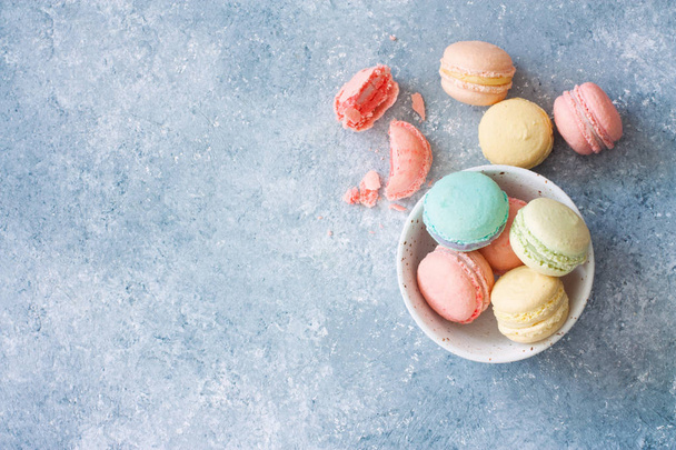 Assortment of colorful homemade  macarons on blue stone background. Top view. Copy space - Foto, Imagem