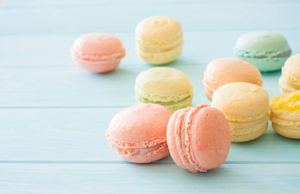 Assorment of colorful homemade  macarons on blue wood background. Close up. Selective focus - Foto, afbeelding