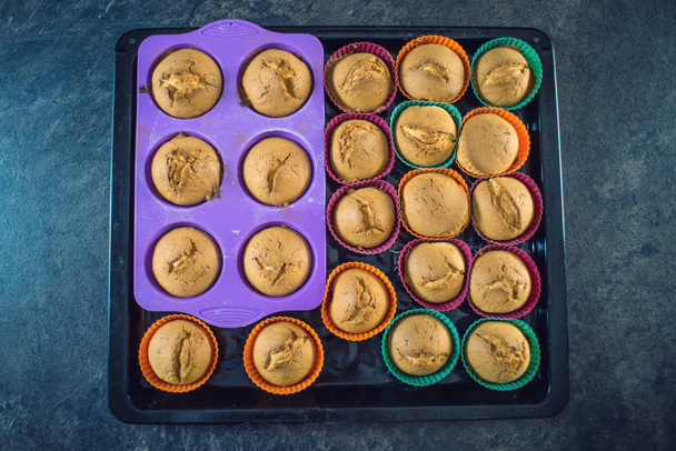 Домашні свіжі кекси з силіконових форм на темному тлі. Вид зверху. Концепція кондитерської кухні
 - Фото, зображення