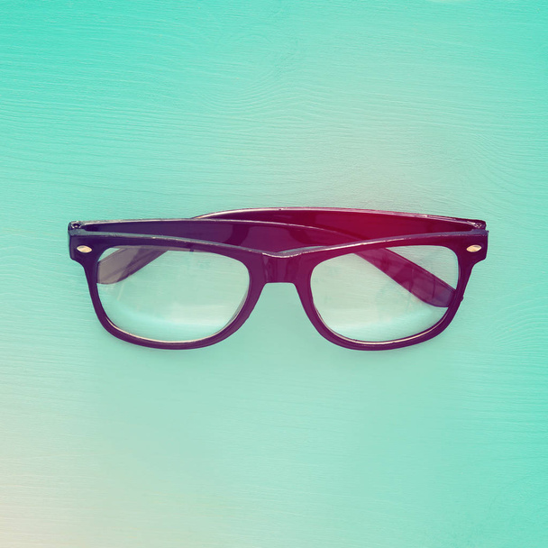 Imagen de vista superior de gafas ópticas negras sobre fondo de madera de menta
 - Foto, Imagen