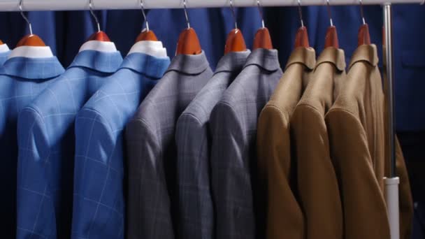 Erkek takım elbise ve ceket bir giyim mağazasında asılı - Video, Çekim