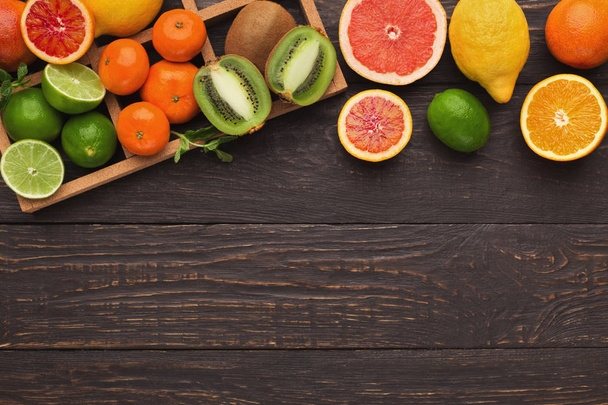 Verscheidenheid van rijpe citruses op houten achtergrond - Foto, afbeelding