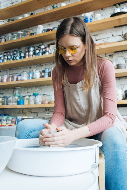 Handcrafted on a potter's wheel,Hands make clay from various items for home and sale in the store and at the exhibition, ceramic items are made in hand, beautiful girl makes products from clay - 写真・画像