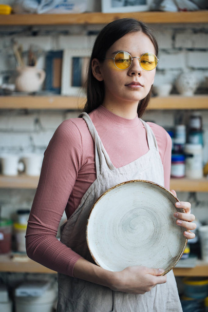 Handcrafted on a potter's wheel,Hands make clay from various items for home and sale in the store and at the exhibition, ceramic items are made in hand, beautiful girl makes products from clay - Foto, Bild