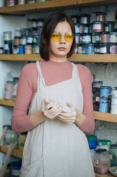 Handcrafted on a potter's wheel,Hands make clay from various items for home and sale in the store and at the exhibition, ceramic items are made in hand, beautiful girl makes products from clay - Фото, зображення