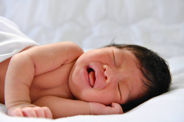 Concepto para recién nacidos. Los bebés recién nacidos duermen en una cama. El bebé está en el dormitorio blanco
. - Foto, imagen
