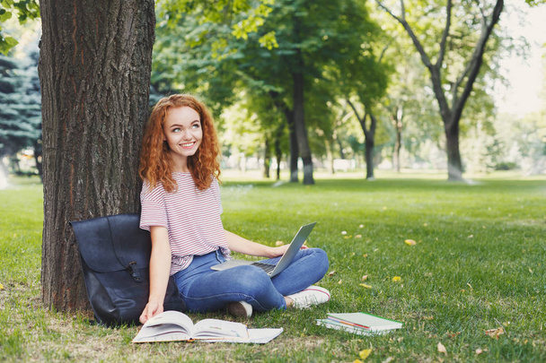 Ελκυστική φοιτητής με laptop και μικρόs φορήτοs σε εξωτερικούς χώρους - Φωτογραφία, εικόνα