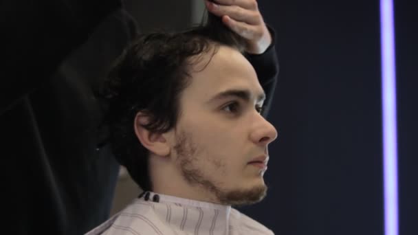 Mokré vlasy řezání mladého muže v barbeshop - Záběry, video