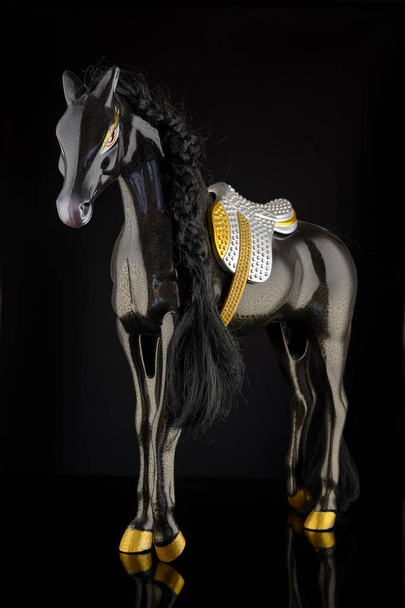 brinquedo de plástico cavalo em um fundo preto
 - Foto, Imagem