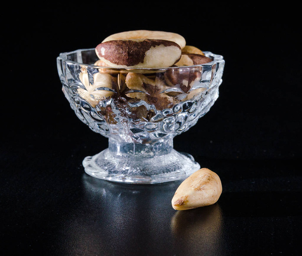 seeds of brazil nuts in glass bowl in darck - Foto, afbeelding