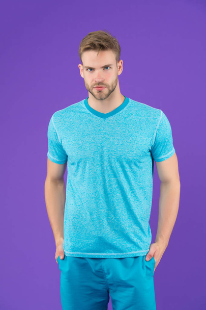 Man in tshirt and shorts on violet background. Guy in blue casual clothes. Macho in active wear for workout or training on purple background. Sport fashion style and trend. Fitness and gym activity. - Φωτογραφία, εικόνα