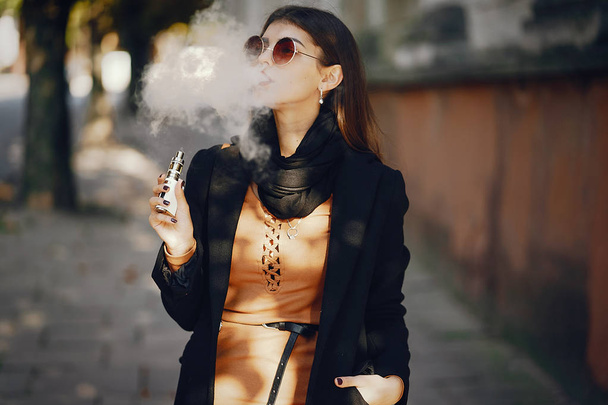 stylish girl smoking an e-cigarette - Фото, зображення