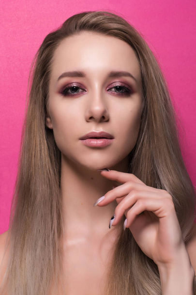 Beautiful young girl on a pink background. - Foto, Imagen