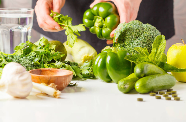 Preparation of green salad. Ingredients for salad on the table. A woman is cooking vegan food. - Fotó, kép