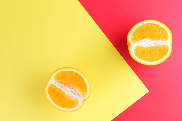 Fruits of oranges on a multicolored background, halves of oranges on colored paper. Copy space. Citrus in the style of pop art - Фото, изображение
