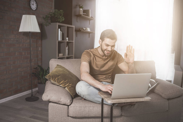 Young bearded man is having online conversation at home - Fotoğraf, Görsel