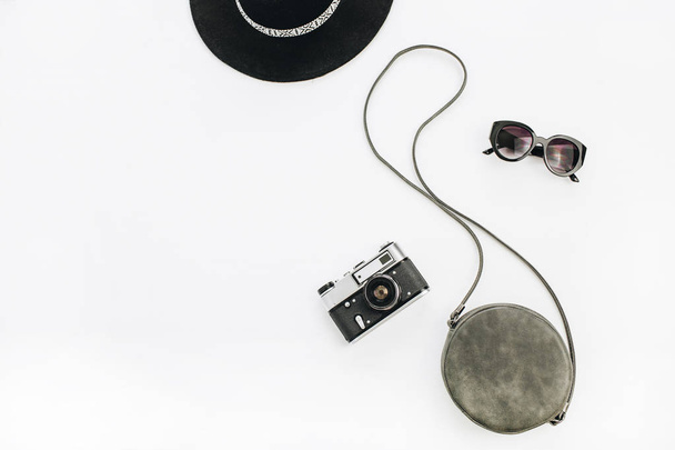 Preto acessórios femininos elegantes: óculos de sol, chapéu, bolsa e câmera retro. Flat lay, vista superior conceito de moda verão mínimo
. - Foto, Imagem