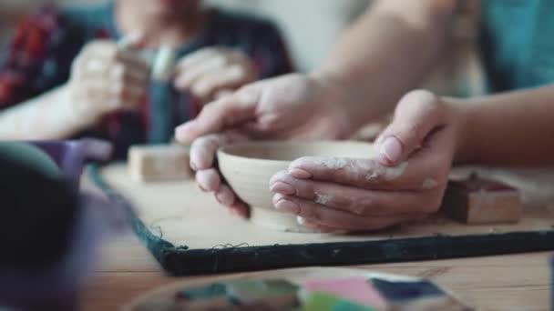 bezetting op handmatige modellering van klei. vrouwelijke handen close-up. meisje beeldhouwt een kleiplaat - Video