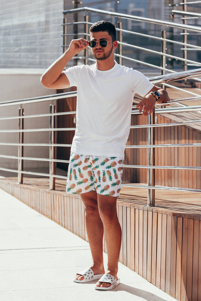 Portrait of young stylish man near the pool deck on sunny summer day. Lifestyle. - Foto, Bild