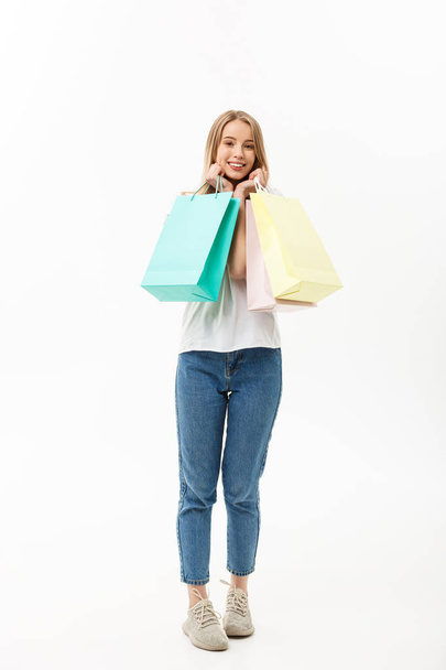 笑顔と白い背景に分離された完全なボディに興奮して立って幸せな買い物袋を保持している買い物客女性の完全な長さ. - 写真・画像