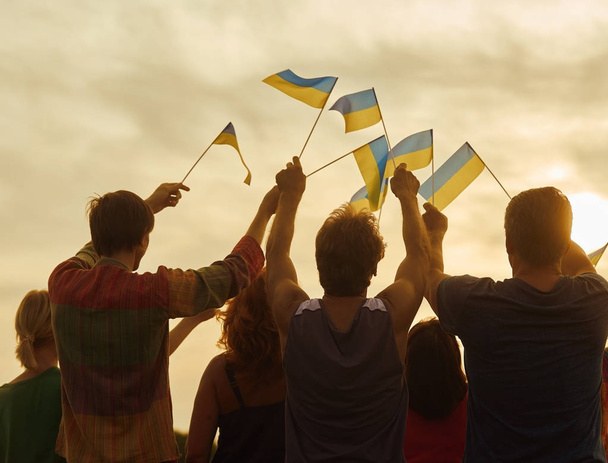 Back view, silhouette of ukrainian people with flags. - Photo, Image