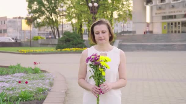 Beautiful lady holding a bouquet of beautiful flowers. Female hand touching beautiful flowers. Enjoying nature - Imágenes, Vídeo