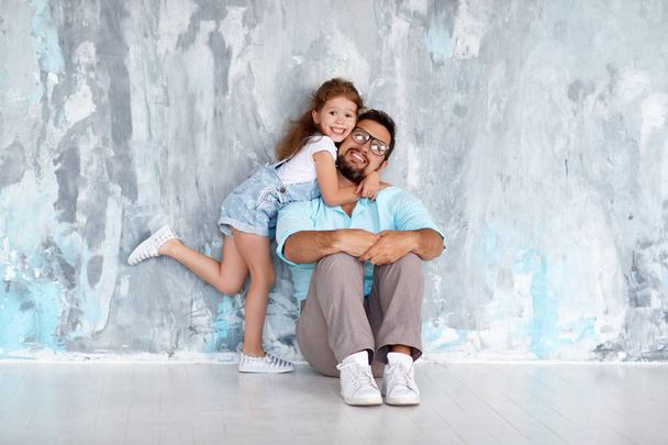 Father's day. Happy family daughter hugging dad and laughs near an empty wal - Photo, Image