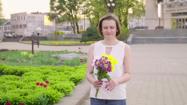 Beautiful lady holding a bouquet of beautiful flowers. Female hand touching beautiful flowers. Enjoying nature - Filmati, video