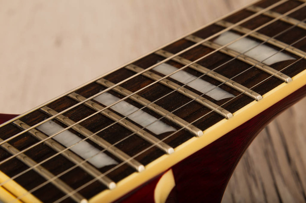 alte schöne E-Gitarre auf einem Hintergrund aus Holz. - Foto, Bild