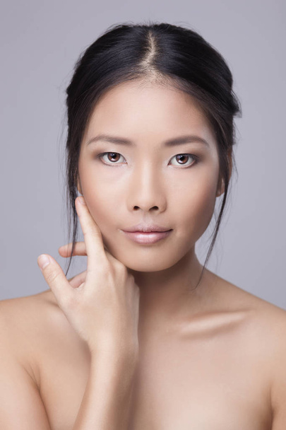 Asian beauty skincare woman touching perfect skin on face. Beautiful wellness beauty care and spa concept with multi-ethnic Chinese Thailand Asian girl with healthy glowing skin on gray background. - Valokuva, kuva
