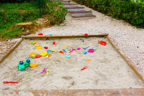 Kinderen speelgoed rondslingeren in zandbank - Foto, afbeelding