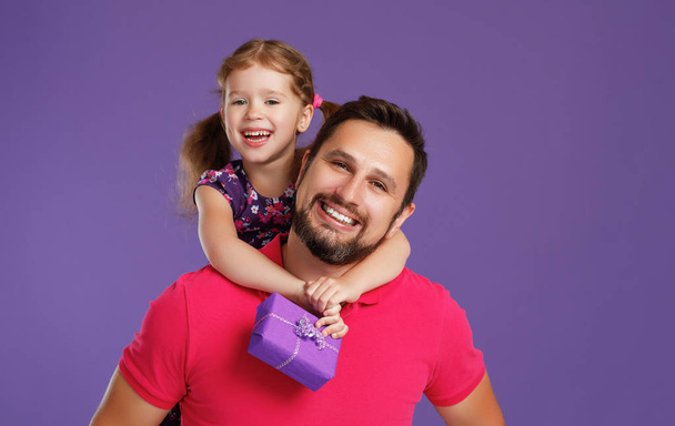 幸せな父の日!かわいい父と娘の色紫背景があるにハグ - 写真・画像