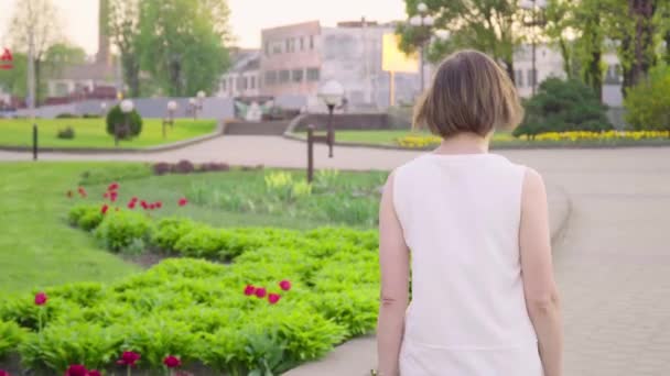 Beautiful woman walking in park - Filmati, video