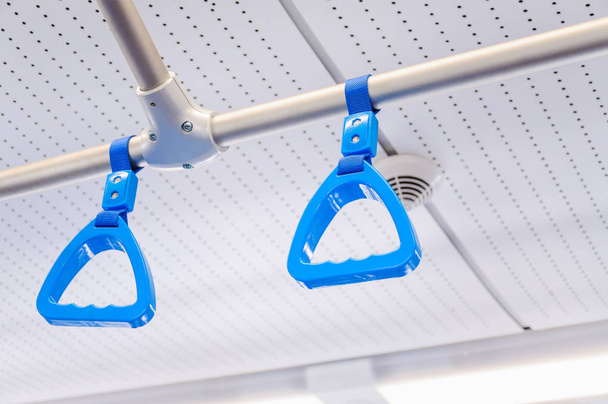 Impiccagione maniglie per i passeggeri in piedi in un treno moderno. Trasporti suburbani e extraurbani
 - Foto, immagini