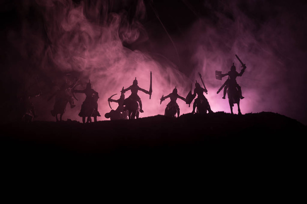 Średniowieczne bitwy sceny z kawalerii i piechoty. Sylwetki postaci jako oddzielne obiekty, walka pomiędzy wojowników na ciemny stonowanych mglisty tło. Scena nocy. Selektywny fokus - Zdjęcie, obraz