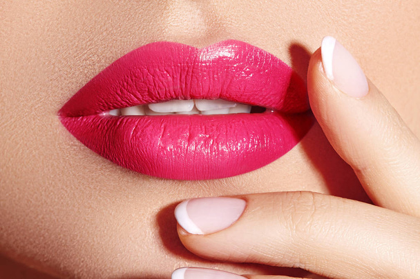 Lähikuva makro laukaus naisen suuhun. Seksikäs Glamour punaiset huulet Meikki aistillisuus ele. Magenta kiiltävä huulipuna. Täyshuulet
 - Valokuva, kuva